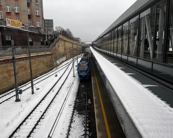 Zimowy dzień na stacji Warszawa Wschodnia. Pociąg IC OSTERWA stoi na torach, a peron pokrywa śnieg.