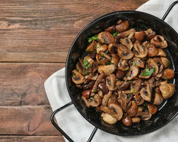 Funghi in padella, dorati e profumati, pronti per essere gustati.
