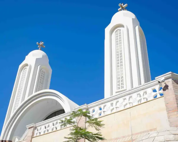 Białe wieże kościoła pod błękitnym niebem. Idealna pogoda w Egipcie w sierpniu, by podziwiać architekturę.