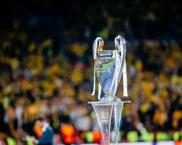 Trofeum Ligi Mistrzów na podium, z tłumem kibiców w tle. Zastanawiasz się, ile za wygranie ligi mistrzów?