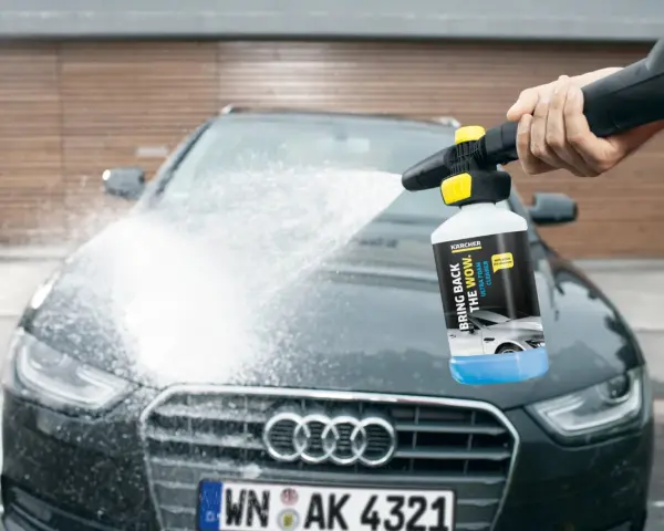 En hand sprutar Kärcher skum på en mörk Audi. Bilen får en djuprengöring med hjälp av Kärcher Ultra Foam Cleaner.