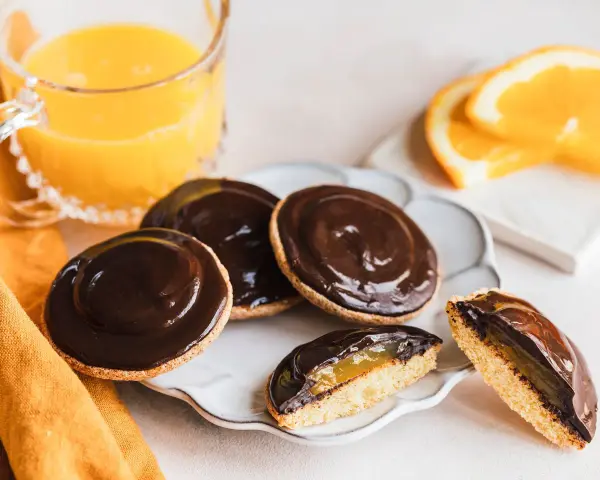 Schokoladige Jaffa Cakes mit Orangenmarmelade, perfekt für ein Jaffa Cake Rezept. Dazu ein Glas Orangensaft.