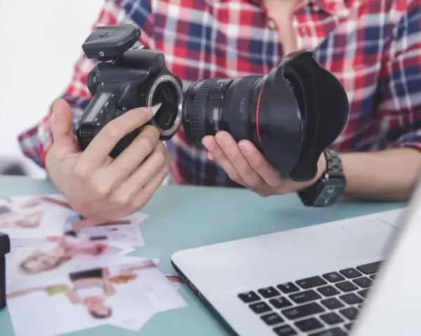 Fotograf przygotowuje sprzęt. Zastanawia się, czy robienie zdjęć z ukrycia jest karalne, przeglądając wydrukowane fotografie.
