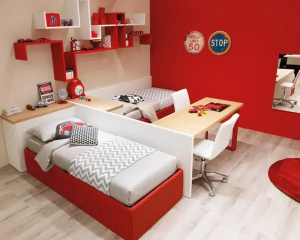 Soluzione creativa per come dividere cameretta maschio e femmina: due letti separati da una scrivania, con arredi a tema auto.