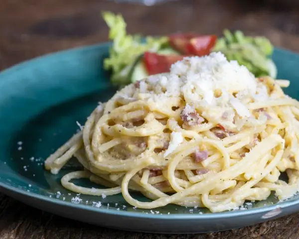 Pyszne spaghetti carbonara posypane startym serem. Szukasz, czym zastąpić ser pecorino? Ten klasyk z pewnością Cię zachwyci.