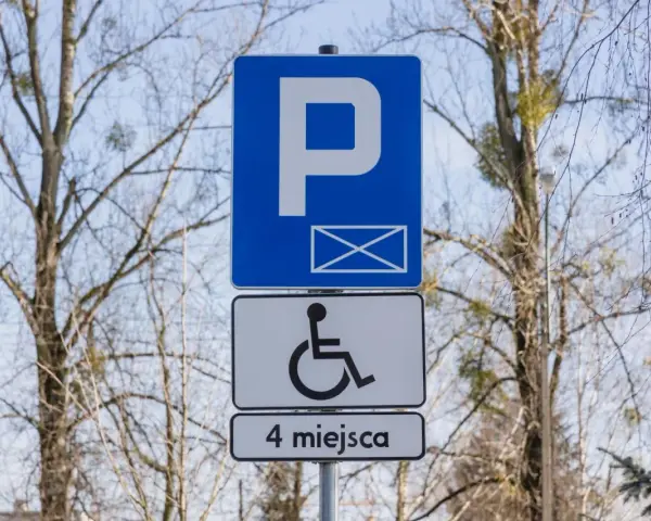 Znak informuje o parkingu dla osób z niepełnosprawnościami. Orzeczenie o niepełnosprawności można uzyskać na wiele chorób, np. schorzenia narządu ruchu.