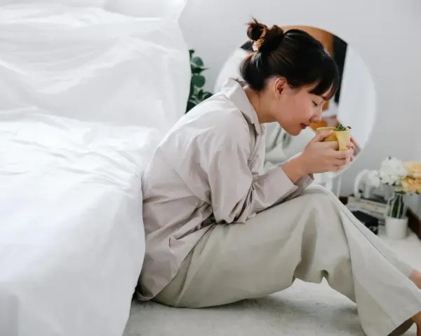 Mujer con taza de té, buscando remedios caseros para dormir de un tirón.