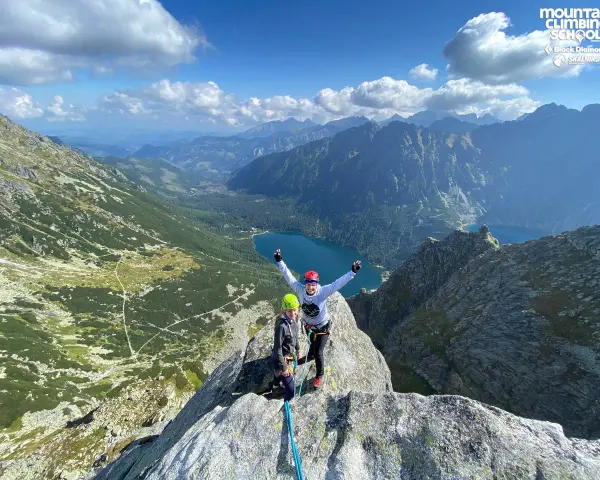Dwóch wspinaczy na szczycie Mnich z widokiem na Tatry i Morskie Oko.