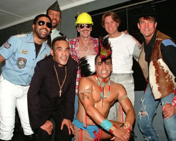 Groupe d'hommes costumés, certains rappelant des figures du disco. Qui a inventé le disco ? Difficile à dire avec ce joyeux groupe !