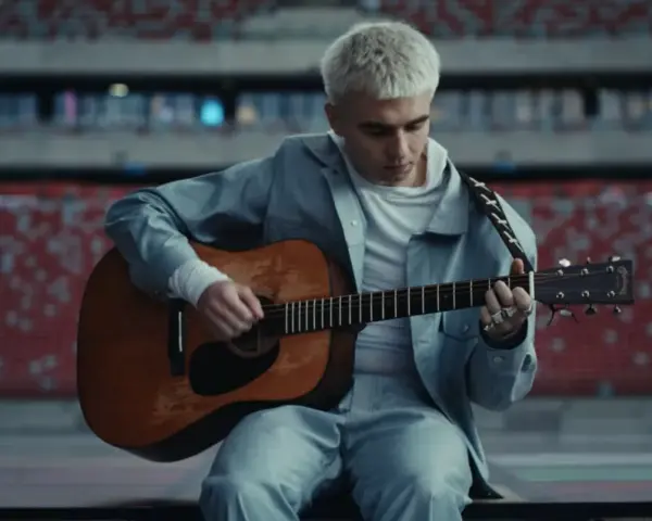 Mata gra na gitarze w pustym stadionie, zapowiadając swój nowy album.