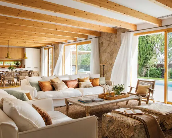 Salones de casas modernas con techos de madera, sofás blancos y vistas a una piscina.