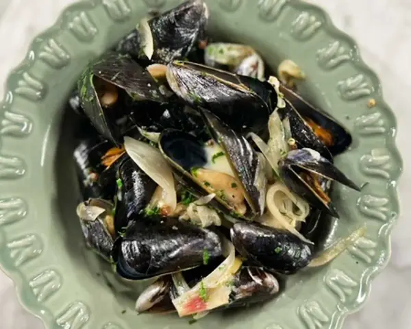 En skål med ångade musslor med lök och persilja. Ett enkelt och gott musslor recept.