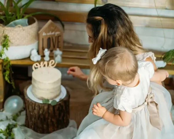 Mama z córką przy torcie na roczek. Piękny tort i dekoracje, idealne na prezent, co kladzie sie dziecku do wyboru na roczek.