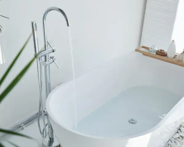 Baignoire moderne remplie d'eau, robinetterie chromée. Idéal pour changer la bonde baignoire sans trappe.