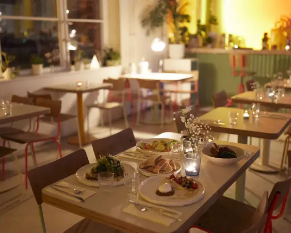 Gemütliche Tische mit Essen und Kerzenlicht im Blumental Berlin.