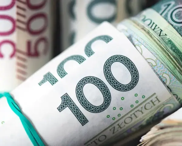 Zwijane banknoty 100 zł i 50 zł związane gumką.