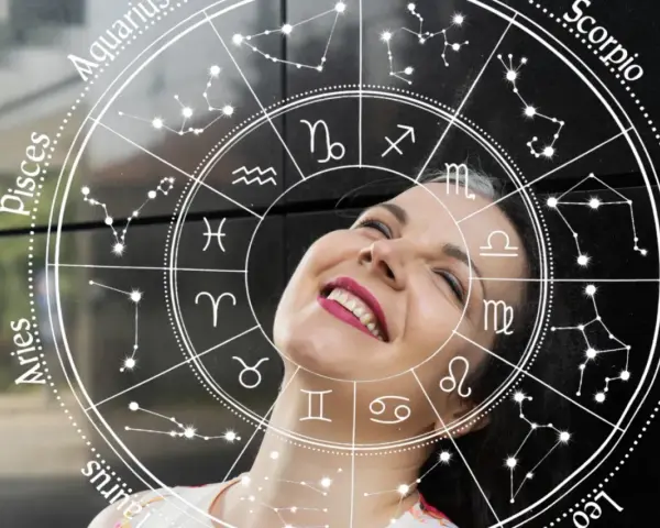 Uśmiechnięta kobieta wpatrzona w koło zodiaku. Sprawdź swój horoskop dzienny Baran i odkryj, co przyniesie Ci dzień!