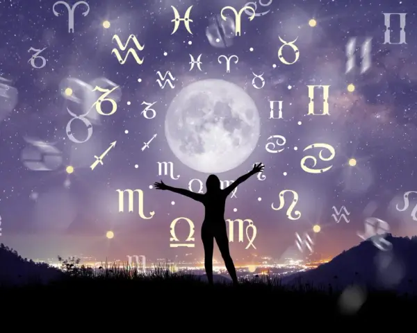 Sylwetka osoby z rozłożonymi rękami pod księżycem i znakami zodiaku. Może to być wizualizacja, gdy **bliźnięta kiedy urodziny** świętują pod gwiazdami.