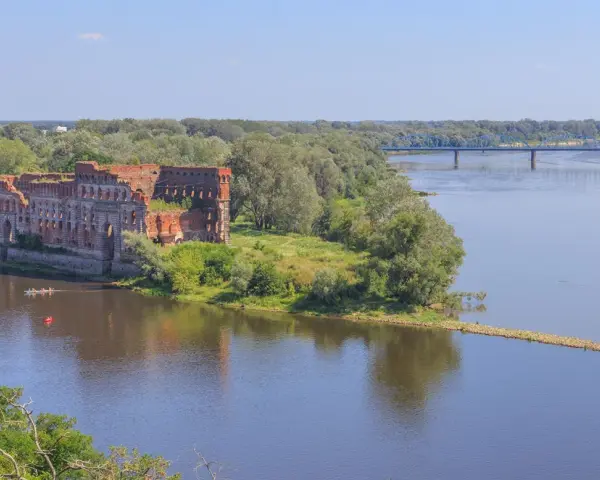 Ruiny twierdzy nad Wisłą, gdzie można poczuć się jak w górach, choć to nie są jakie góry są najbliżej Warszawy. W oddali błękitny most.