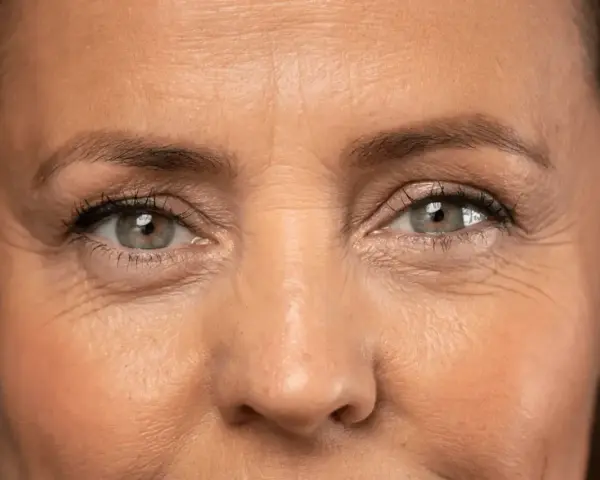 Primer plano de unos ojos con arrugas en los ojos a los 40, reflejando una vida de sonrisas y experiencias.