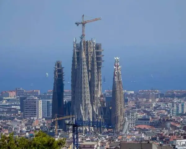 La Sagrada Familia, en plein temps de construction, domine le paysage urbain de Barcelone. Des grues témoignent de l'évolution de ce chef-d'œuvre architectural.
