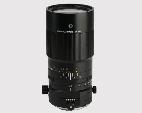 Czarny obiektyw makro 100mm f/2.8 z oznaczeniami odległości i przysłony.