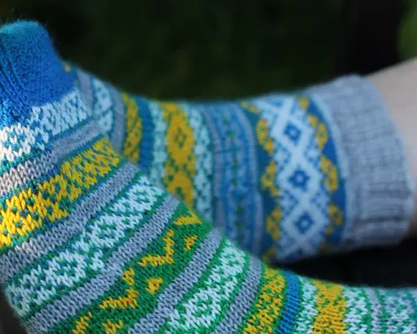 Två par stickade sockor med färgglatt sticka mönster med två färger i blått, gult, grönt och vitt.