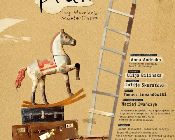 Drewniany, niebieski ptak na bieżni, obok drabiny i walizek.