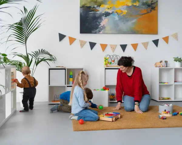 Bambini giocano in una stanza colorata, con scaffali pieni di giochi. Ottime idee stanza giochi bambini per un ambiente stimolante.