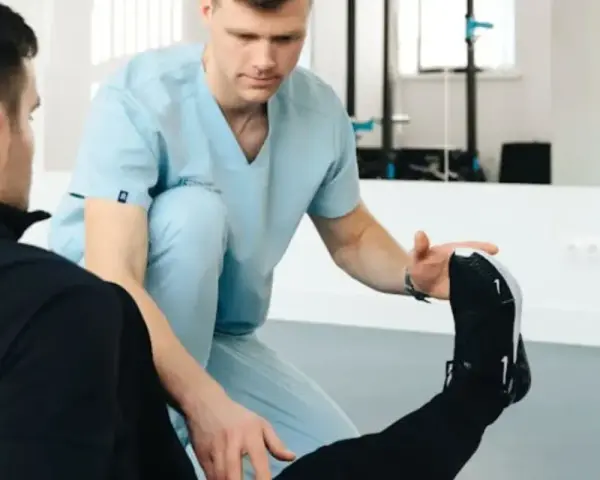 Fizjoterapeuta sportowy pomaga pacjentowi w ćwiczeniach. Zastanawiasz się, ile zarabia fizjoterapeuta sportowy?