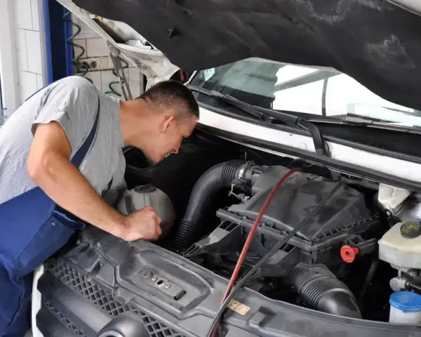 Mechanik bada silnik, szukając przyczyn opóźnionej reakcji na gaz diesel.