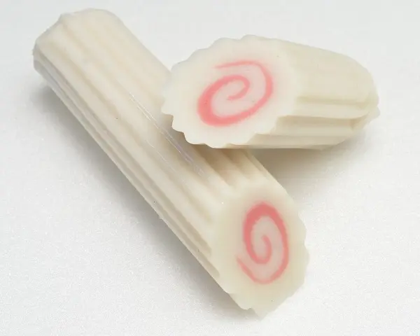 Dwa kawałki narutomaki, japońskiej rybnej pasty z różową spiralą w środku.