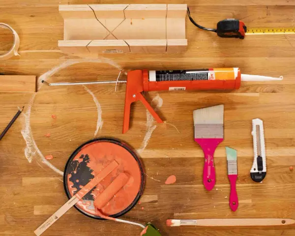 Werkzeuge für Malerarbeiten: Acryl, Stoff, Klebeband und Farbe, die zu schwitzen scheint.