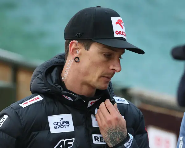 Thomas Thurnbichler, wiek nieznany, w czapce z orłem Orlen i słuchawką w uchu, z tatuażem na dłoni.