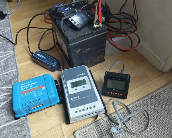 En batteriladdare och solcellsregulatorer kopplade till ett batteri. Var försiktig, ett kokande batteri är farligt.