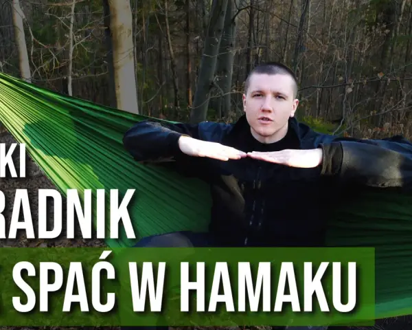 Mężczyzna w lesie pokazuje, jak prawidłowo wykonać mocowanie hamaka, by wygodnie spać w naturze.