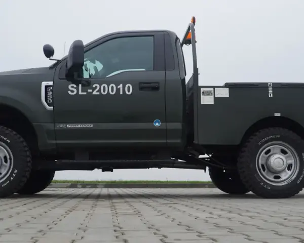 Ciemnozielony Ford F350 z zabudową typu "flatbed" i numerem SL-20010. Solidna maszyna gotowa do pracy.