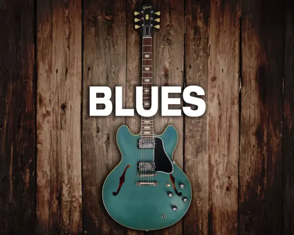 Eine teal-farbene E-Gitarre mit dem Wort "BLUES" darüber, auf rustikalem Holz Hintergrund.