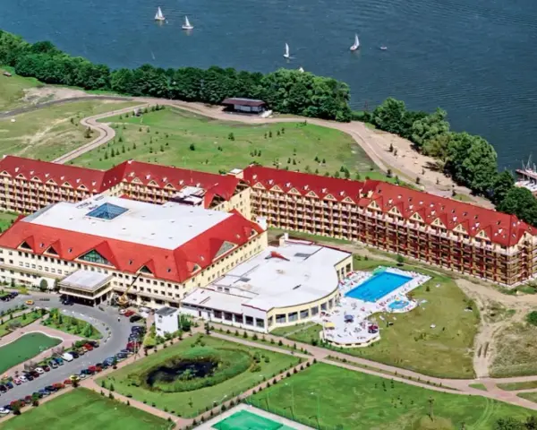 Ogromny hotel Gołębiewski w Karpaczu, z basenem i widokiem na jezioro, ma wiele pokoi, by pomieścić wszystkich gości.