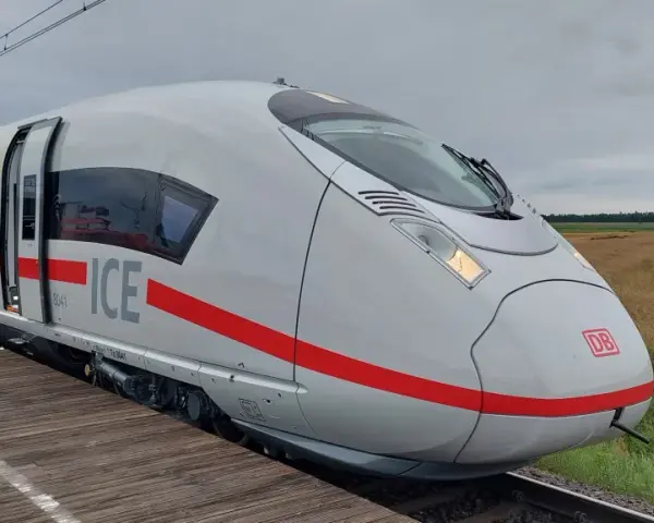 Nowoczesny, biały pociąg ICE 3neo z czerwonym pasem, stojący na peronie.