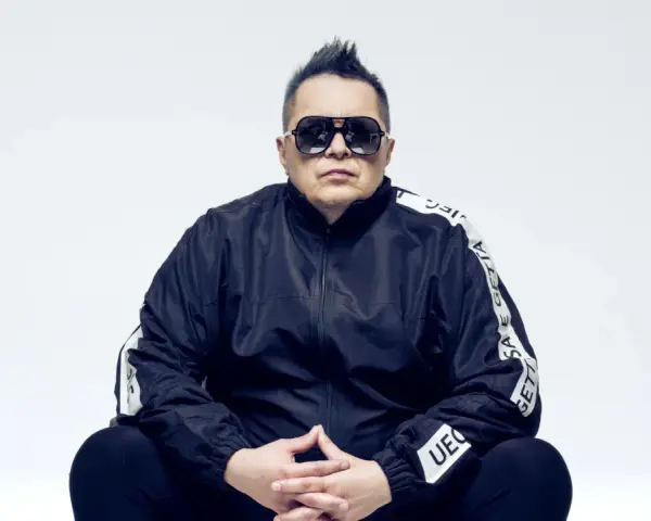 Marek "Mrozu" Mróz w okularach i czarnej kurtce z napisem "GETTA", jakby szykował się na koncert zespołu Munka Staszczyka.