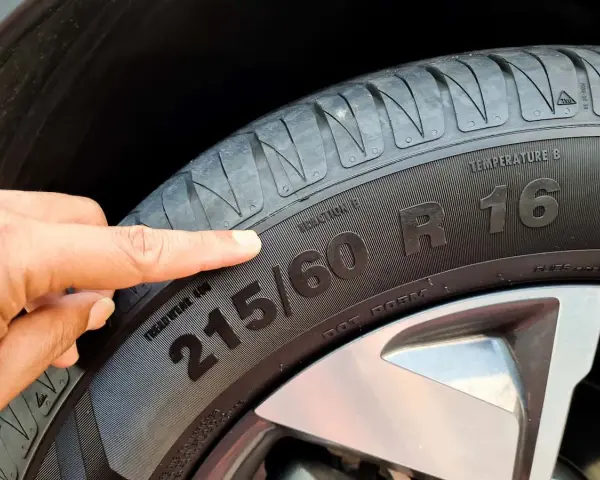 Palec wskazuje na oznaczenie opon zimowych 215/60 R16.