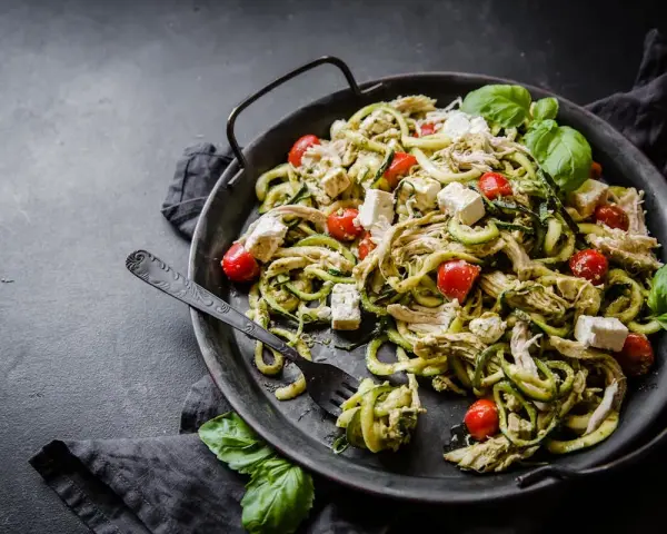 Zucchinipasta med kyckling, tomater och fetaost. Ett perfekt protein recept för en lätt och god måltid.