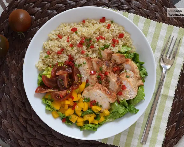 Bowl con quinoa, pollo a la plancha, tomates y mango. Un plato ideal de alimentos saciantes para adelgazar.