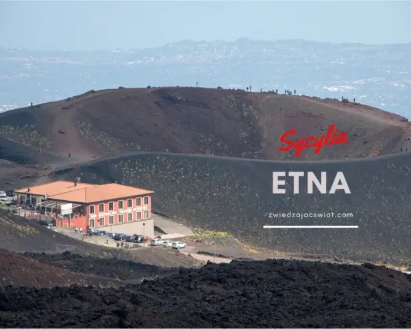 Wulkan Etna na Sycylii, z charakterystycznym budynkiem i turystami na zboczu. Odkryj niezwykłe walory przyrodnicze Włoch.