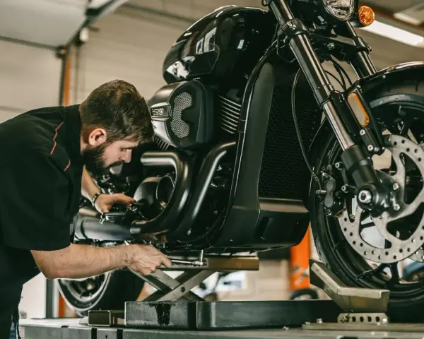 Meccanico al lavoro su una moto. Per sapere i tagliandi Ducati ogni quanti km, consulta il manuale.
