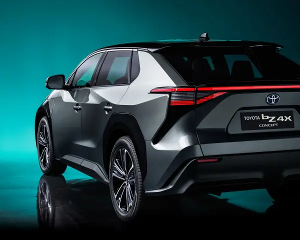 Tył samochodu Toyota bZ4X Concept na tle turkusowego tła.