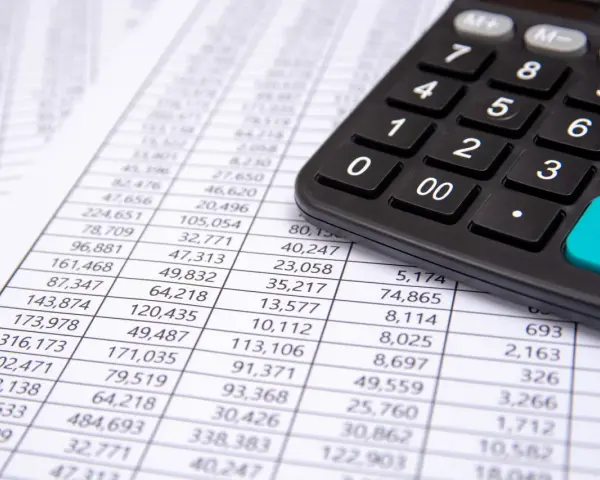 Calculadora sobre hoja de cuentas, mostrando posibles remuneraciones pendientes de pago activo o pasivo.