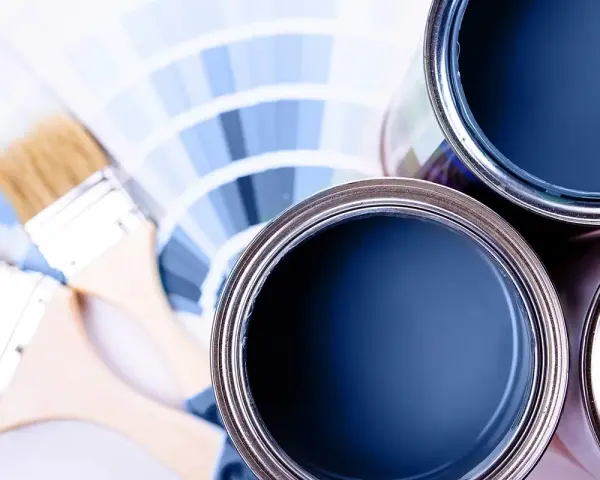 Lattine di vernice blu e pennelli su campioni di colore. Ideale per la vernice per mdf.