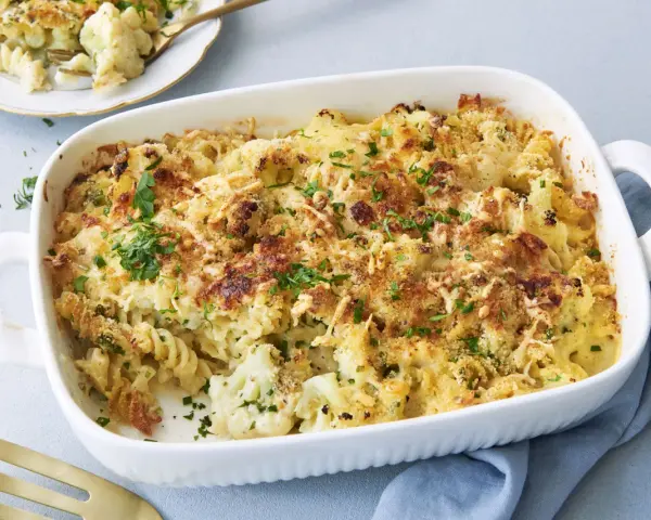Ein goldbrauner blumenkohl nudel auflauf mit Käse überbacken und frischer Petersilie garniert, bereit zum Servieren.